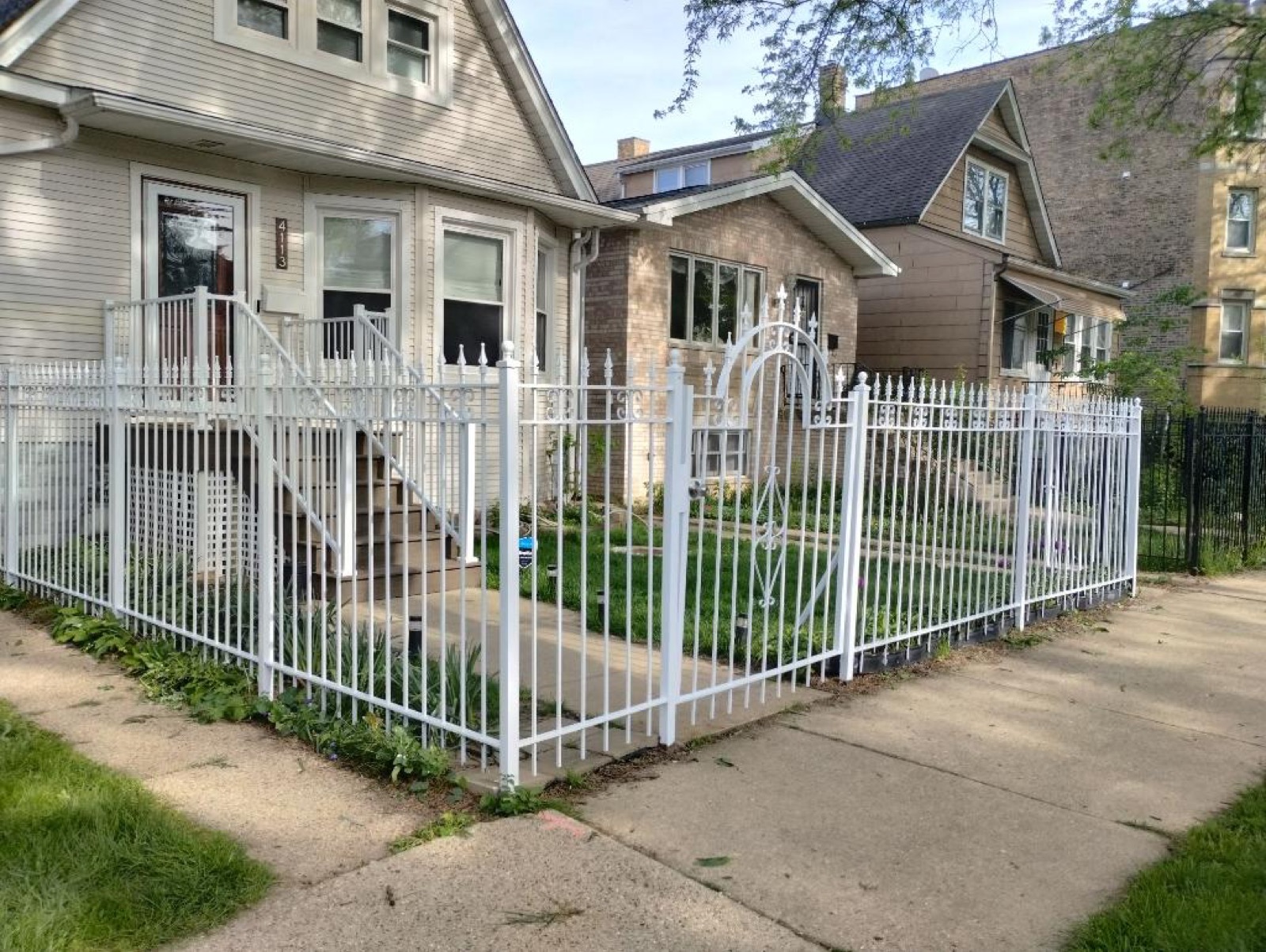 Black horizontal steel railing installed on a small porch stair entry.