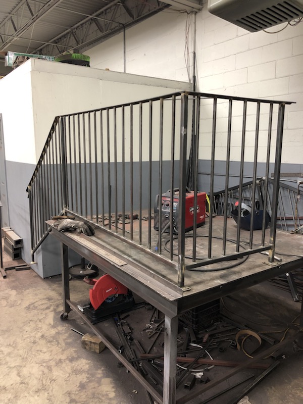Custom railing section fabricated in the shop on a steel work table.