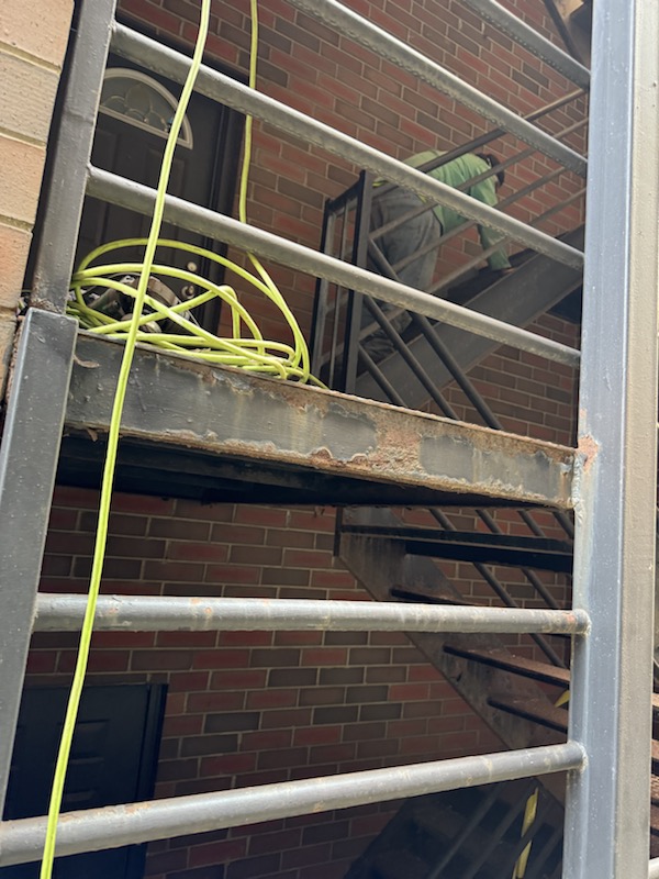 Rusted side framing and worn stair structure before repair and finishing work.